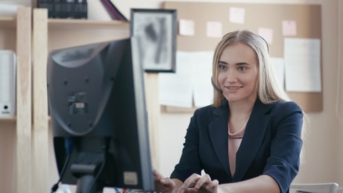 Call Center Employee at Work in the Office. A Young Girl Sitting at the Computer in the Office. The