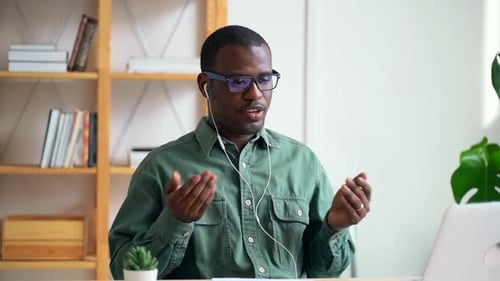 African American Man Having Video Call and Using Laptop at Table in Modern Office Spbas