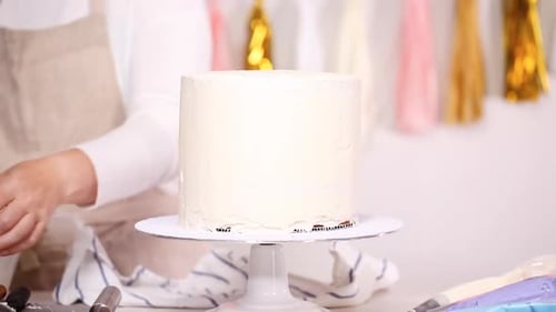 Schritt für Schritt. Konditor stapelt Kuchenschichten mit Buttercreme-Zuckerguss dazwischen, um ein Einhorn zu kreieren c