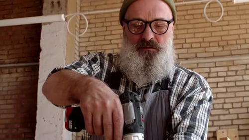 Man Using Drill in Workshop