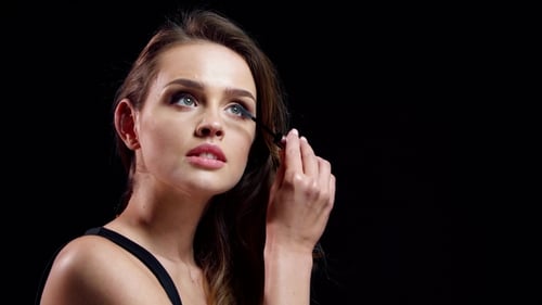 Wimpern-Make-up. Schöne Frau, die Wimperntusche auf
die Wimpern aufträgt