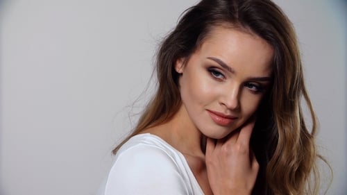 Attractive Woman with Wavy Hair Posing in Studio