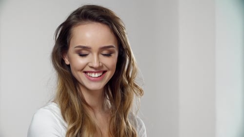 Smiling Woman with Wavy Hair Poses in Studio