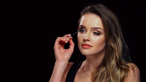 Woman Applying Mascara in Close-up Studio Shot