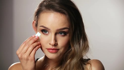 Beautiful Woman Applies Makeup with Sponge
