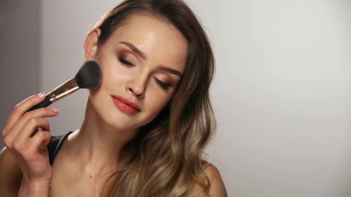Beautiful Woman Applying Makeup with Brush, Close Up