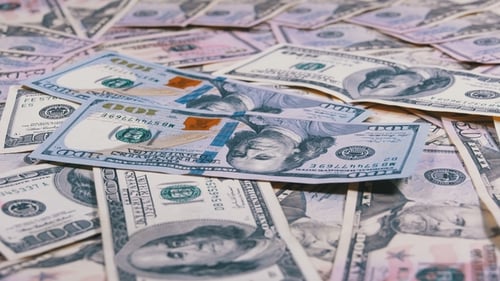 One Hundred Dollar Bills Fall on the Table with American Dollars of Different Denominations