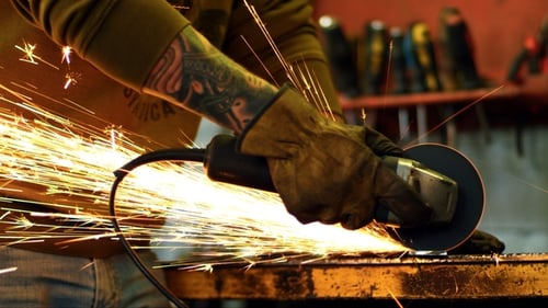 Trabajador corte metal con amoladora