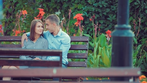 Young Couple Spend Time Together on a Bench in a Holiday Park
