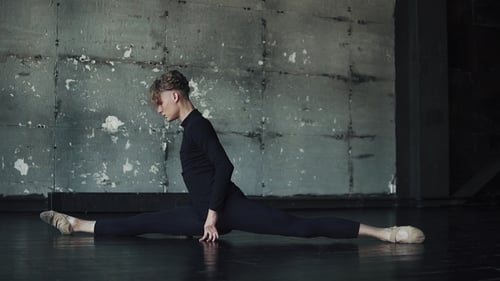 Male Ballet Dancer Sitting on Twine on the Floor and Doing Stretching