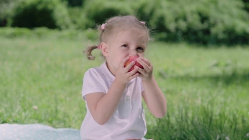 Healthy Nutrition. Child Eating Juicy Apple Outdoors