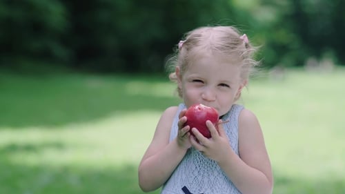 Kind isst saftigen Apfel im Freien