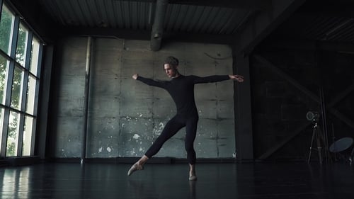 Male Ballet Dancer Dancing Classical Ballet in a Dark Studio.