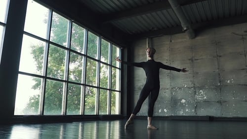 Young Male Ballet Dancer Dancing in Studio on a Dark Background