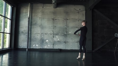 Male Dancer Is Spinning on Tiptoe in Studio on a Dark Background
