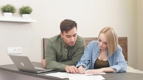 Young Couple Reviews Finances at Home Together