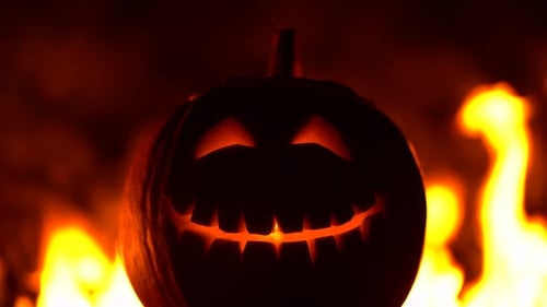 Schwarzer lächelnder glücklich geschnitzter Halloween-Kürbis vor feuriger Explosion Leuchtendes Gesicht
