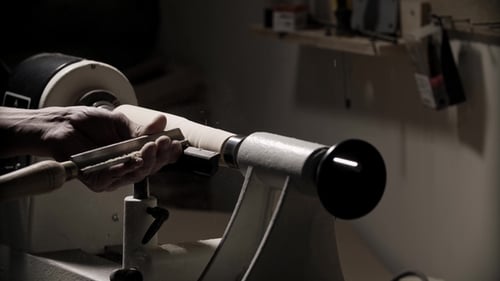 Man Working on Woodworking Lathe Machine in Carpenter Workshop