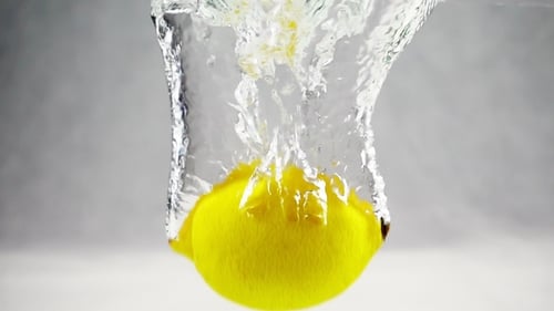 Bright Yellow Lemon Dropped Into Water