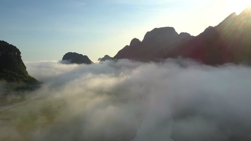 Along River Hidden By Fog Against Hills and Sky