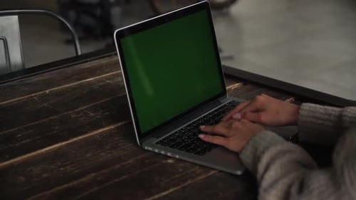 Woman Typing on Laptop with Chroma Key Screen