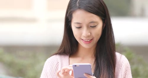 Woman Using Cellphone Outdoors During The Daytime