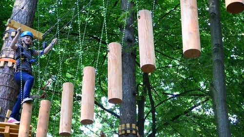 Teenager on Ropes Course Adventure in Green Forest