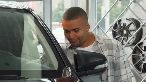 Handsome Young African Man Smiling Holding Car Keys at the Dealership