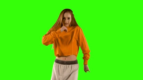 Young woman dancing against green screen background