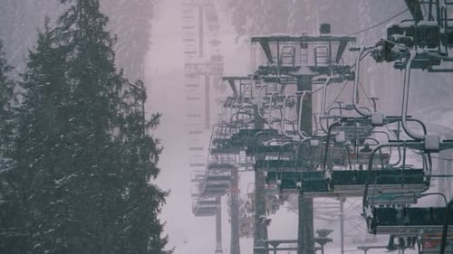 Telesquí en la estación de esquí, cámara lenta. Los esquiadores suben al elevador de sillas de esquí a la pista de esquí con caída