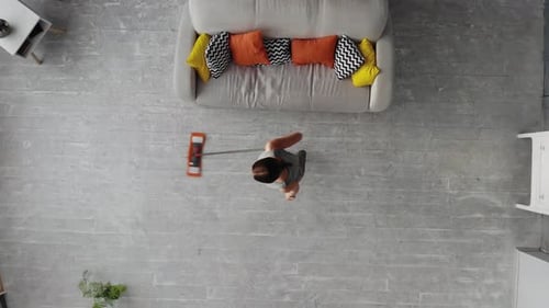 Woman Housewife Wash Wooden Floor in Living Room. Top View