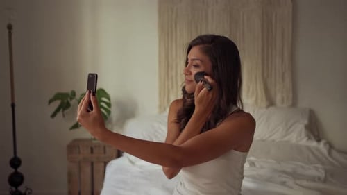 Woman Applying Makeup While Recording Smartphone Video