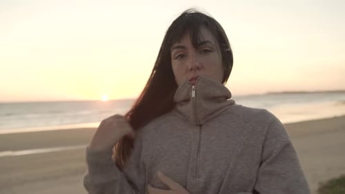 Traveling woman standing on beach at sunset