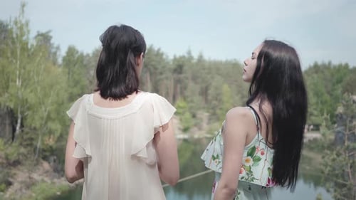 Back of Two Young Woman Standing in the Top of Mountain and Looking at Amazing View of Hill