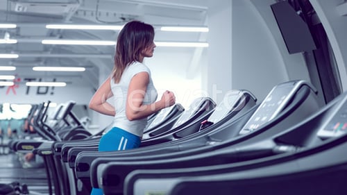 Adult Woman Runs on Treadmill at the Fitness Centre