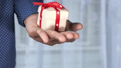 Small Heart Shape Gift on Man Hand Close Up