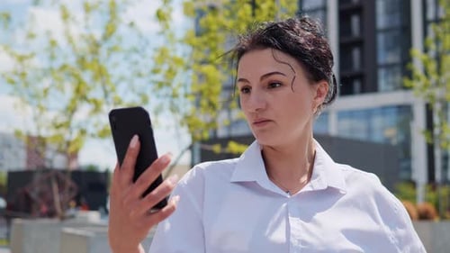 Woman Uses Phone for Video Call Outdoors