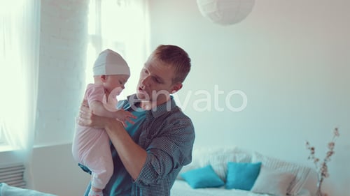 Happy Father Holding His Infant Child at Home