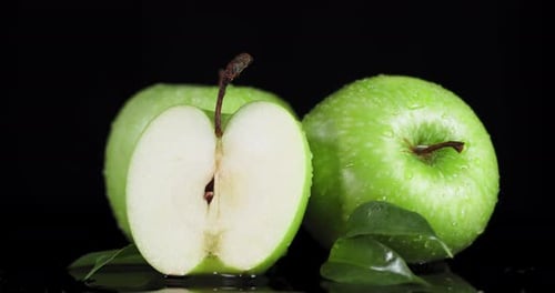 Rotierende frische grüne Äpfel mit Wassertropfen.