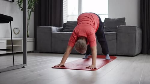 Mature Woman Exercising on Yoga Mat at Home