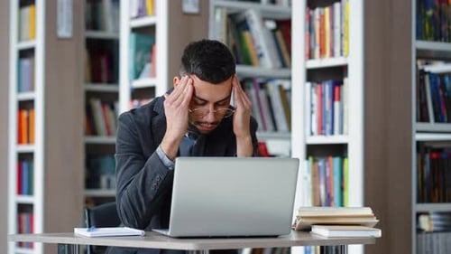 Man having headache when working on laptop