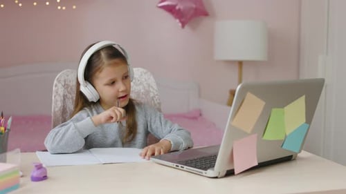 Schulmädchen studiert online auf Laptop zu Hause