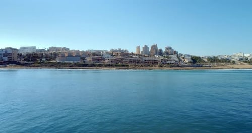 Drone Fly Above Sea Along the Coastline Rocks and Looking to the Cityscape