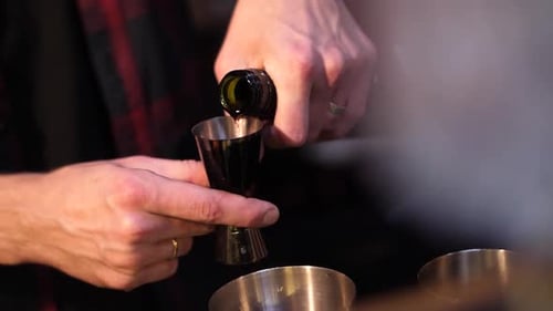 Einen alkoholischen Cocktail zubereiten. Der Barkeeper schenkt einen Cocktail ein. Cocktail in einem Glas.