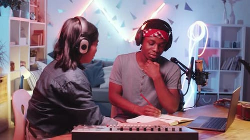 Diverse Male and Female Musicians Writing a Song in Home Recording Studio