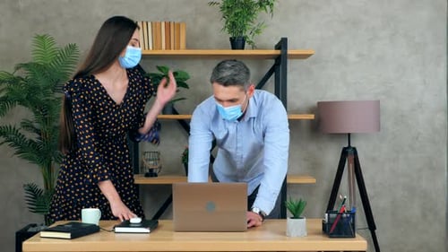 Woman and Man Work Together at Desk, Masks