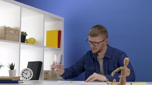 Junger gutaussehender Maler, Illustrator, Designer Arbeiten am Layout, Dummy Vordergrund