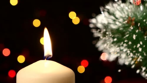 Burning Candle with Christmas Tree and Festive Lights