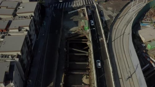 AERIAL: Birds Eye View of Downtown Los Angeles Street with Cars,Traffic,Tram and Tilt Up To Skyline