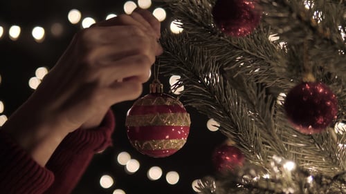 Decorating Christmas Tree with Red and Gold Ornaments